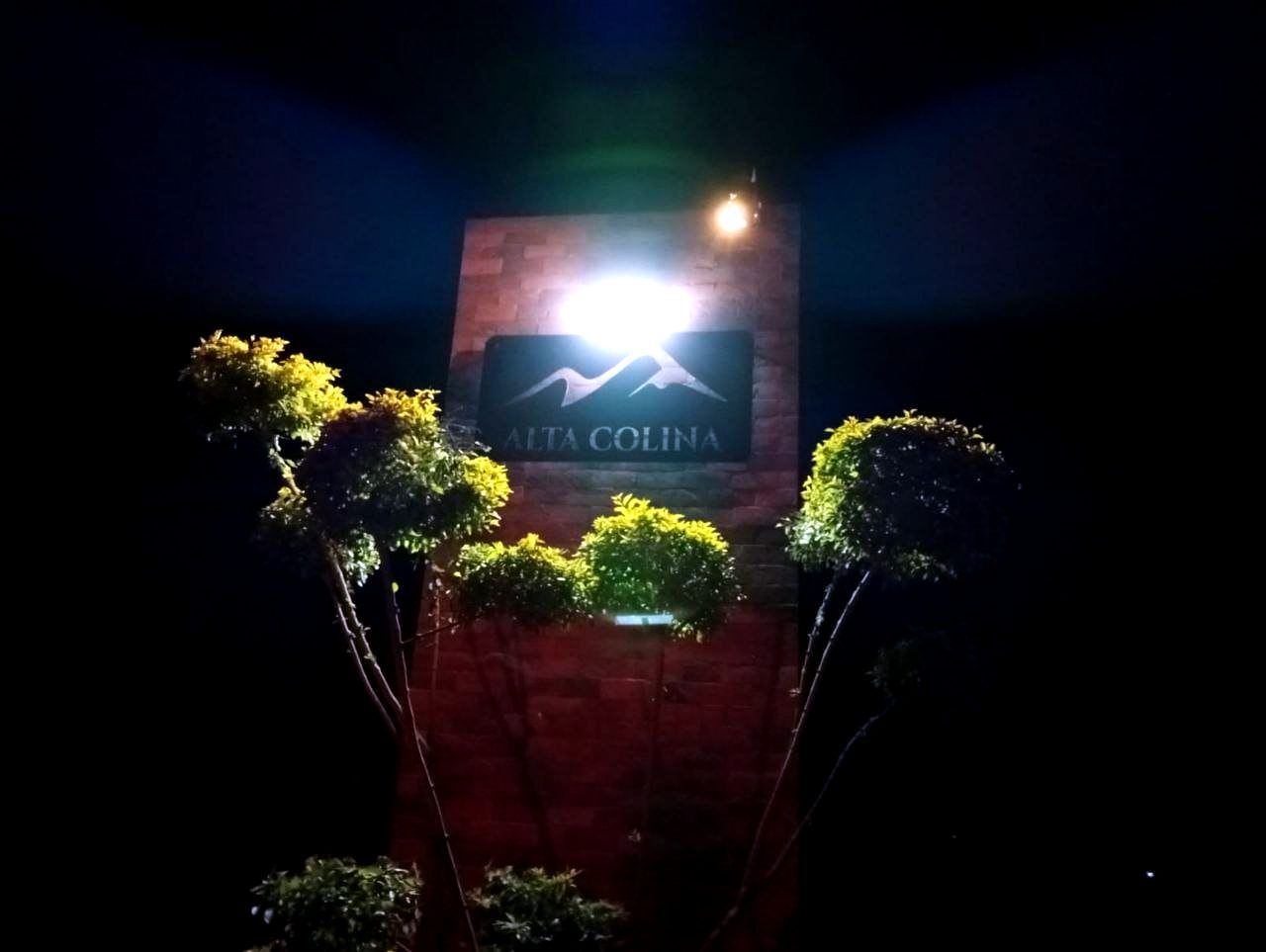 El letrero de Alta Colina iluminado de noche